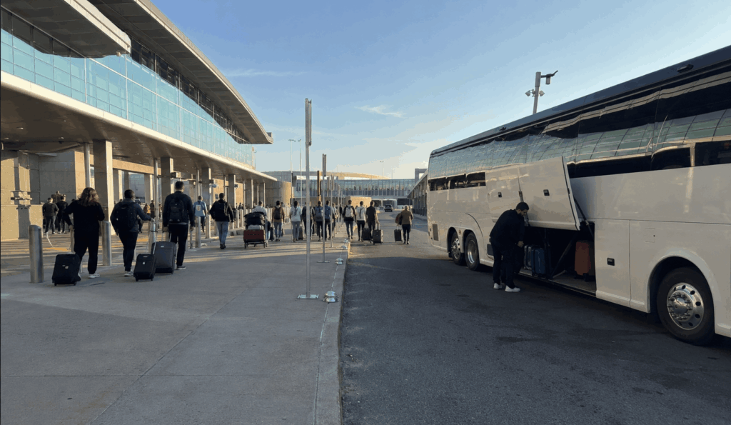 group travelers unloading luggage from a charter bus at cleveland hopkins airport departures area