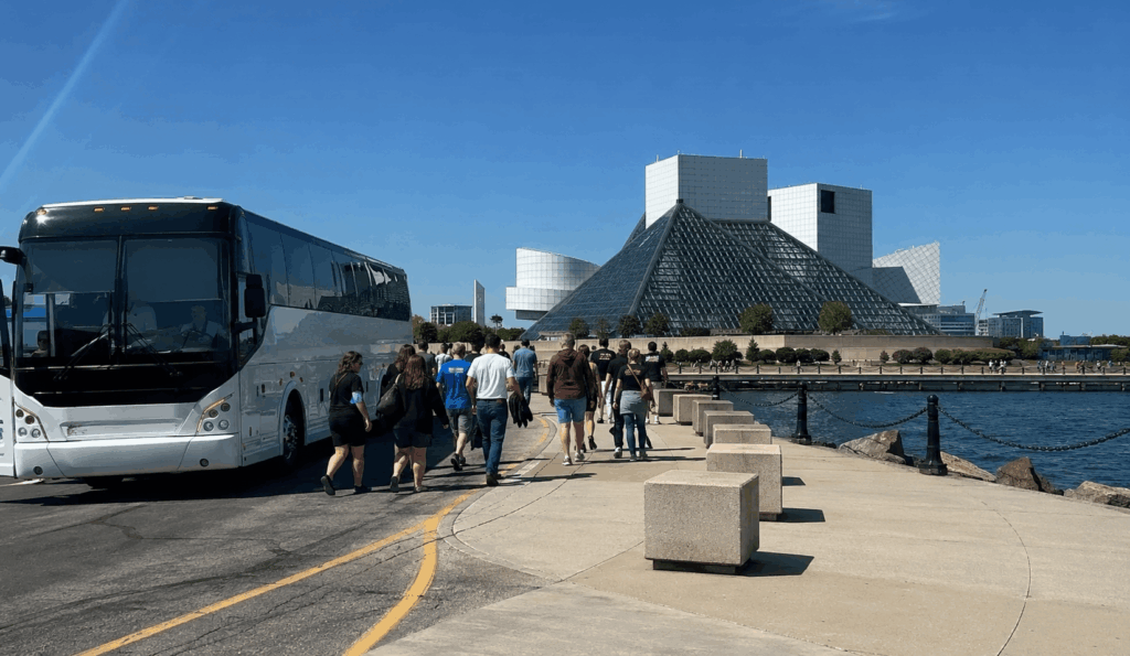 charter bus dropping off a group outside the rock and roll hall of fame on cleveland's lakefront